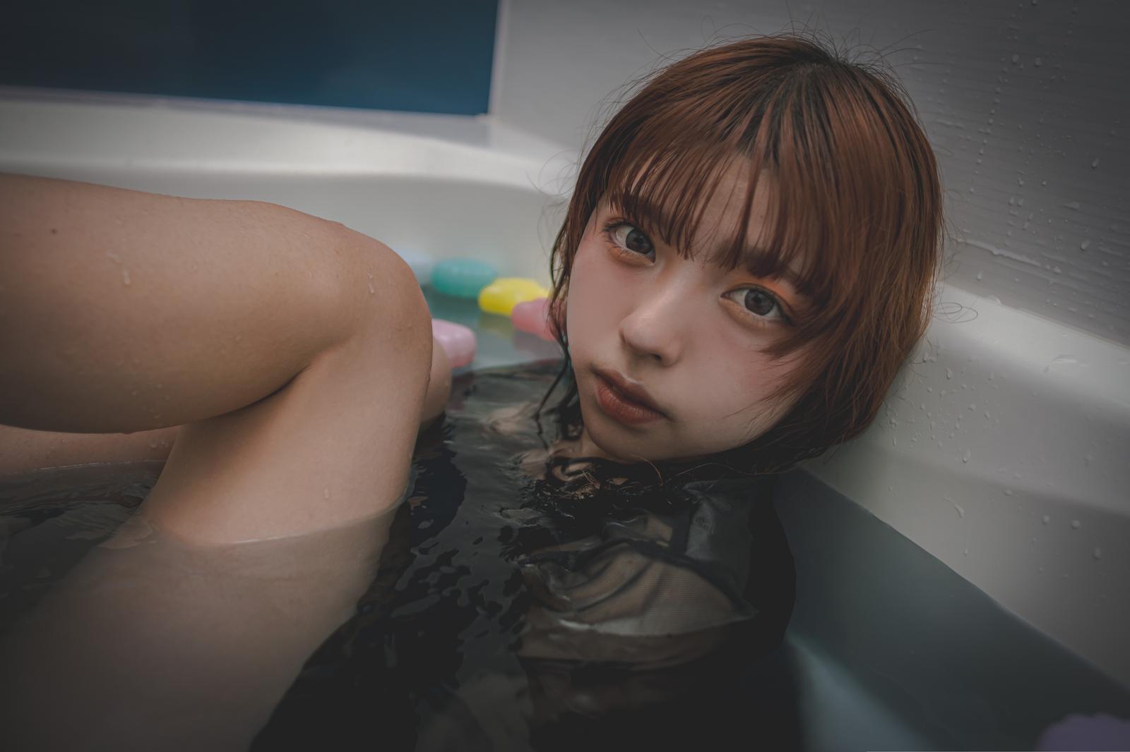 浴槽の縁に頬を寄せてこちらを見つめる、ショートボブの女性［モデル：高尾実生］