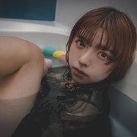 浴槽に浸かりこちらを見つめる女性の写真
