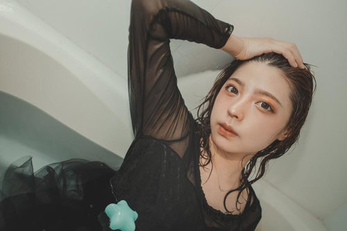 リラックスした表情で髪をかきあげる湯上がり女性