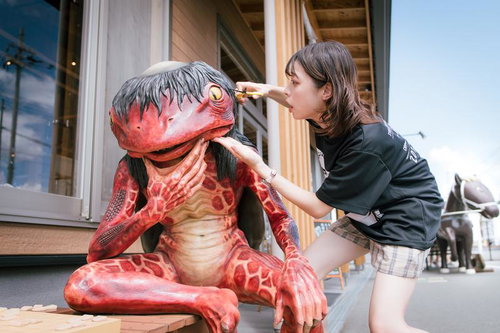 屋外で妖怪ベンチの髪を切る女性