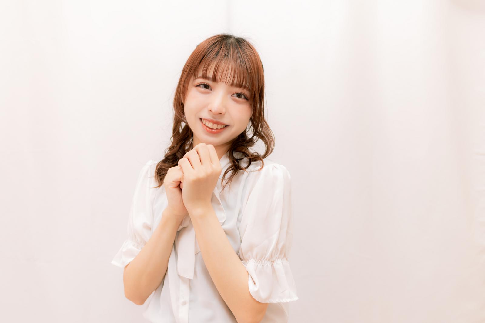 白いシャツを着たアイドルがファンに笑顔で対応している握手会の様子［モデル：高尾実生］