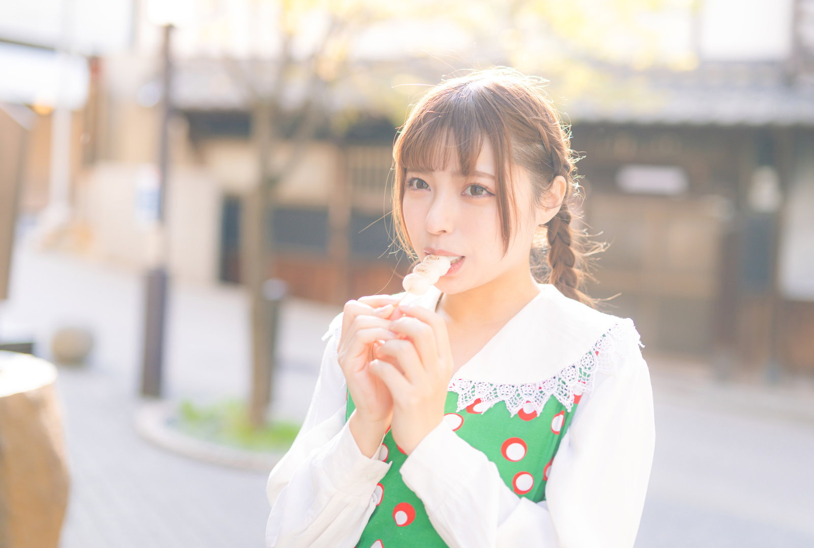 串団子を食べ歩きする女性［モデル：高尾実生］