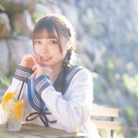 カフェでくつろぐ制服姿の女子高生がドリンクを片手に笑顔の写真