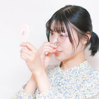 ビューラーで目を大きくするメイクテクニック、眼鏡をかけた女性の横顔の写真