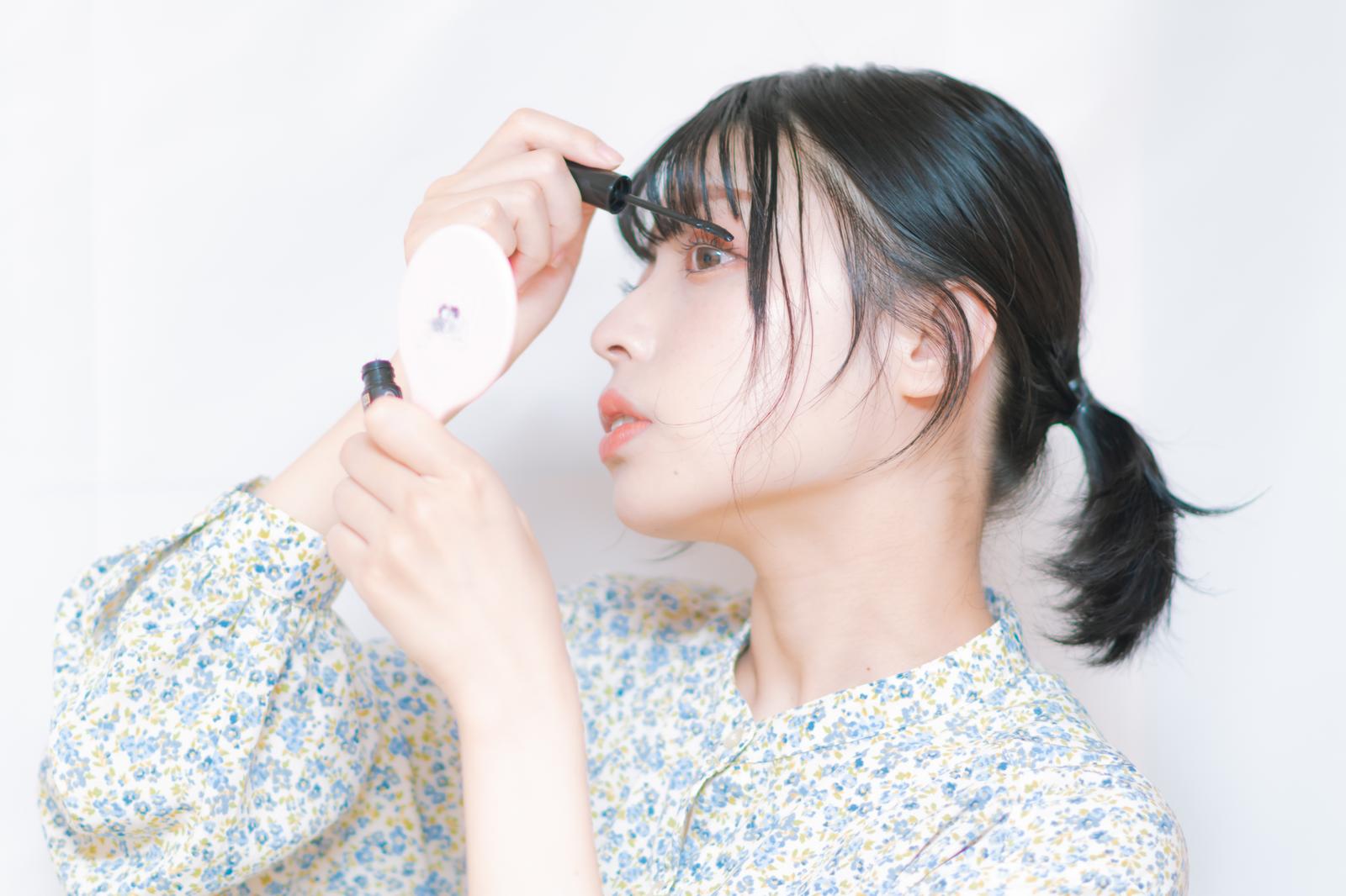 マスカラを塗るメイクアップ中の女性の横顔［モデル：高尾実生］