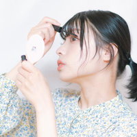 横顔で映すマスカラを塗る女性のメイクアップテクニックの写真