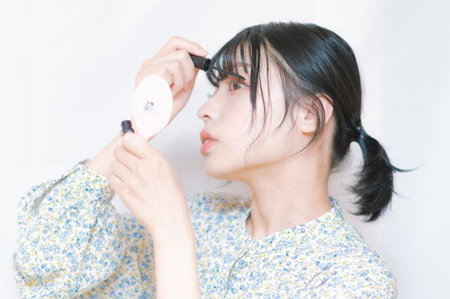 横顔で映すマスカラを塗る女性のメイクアップテクニック