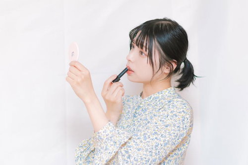 鏡を見ながら口紅を塗るビューティーテクニック