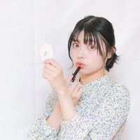 唇に口紅を塗るメイクアップのシーン、鏡を見ながらリップメイクする女性の写真