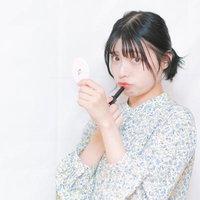 グラマラスな唇のための口紅とグロスを手に持つ女性の写真