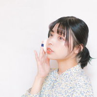 リップパフとコスメで唇を整える女性のメイクアップの写真