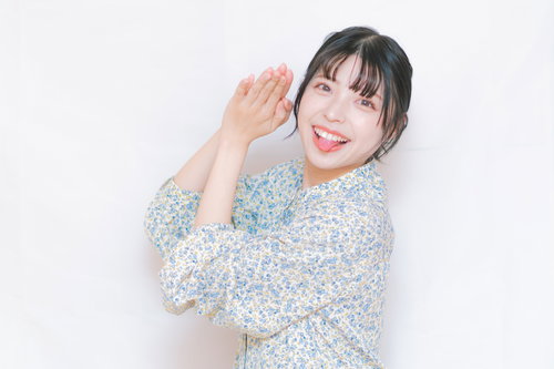 ハッピーで埋め尽くす笑顔の嫁、花柄ブラウスで両手を上げたポーズ