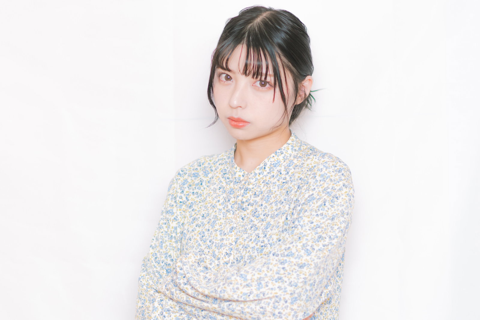 不機嫌そうに睨む女性。花柄シャツ姿で怒った表情をしている［モデル：高尾実生］