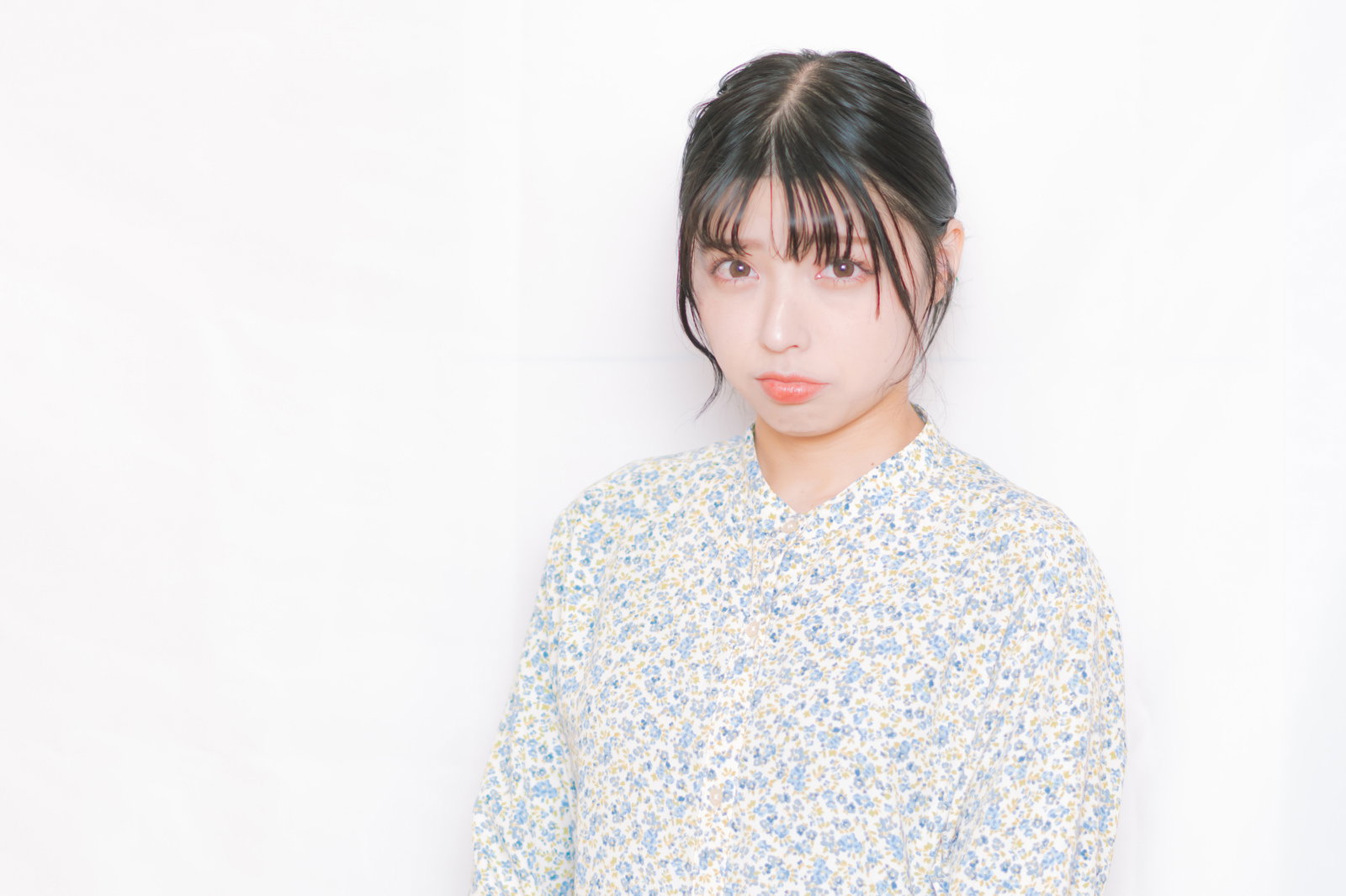 不機嫌な表情で黙り込む女性［モデル：高尾実生］