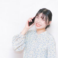 嬉しい知らせを電話で聞いて笑顔が溢れる女性の写真