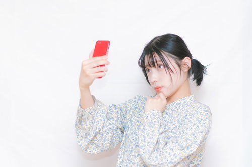 盛れる位置からスマホで自撮りする女性のセルフィ