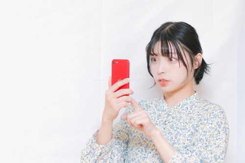 スマートフォンで自分の写真が広告に使われているのを発見した女性