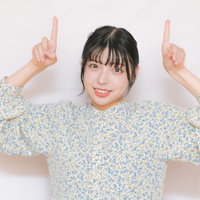 上部を指差して笑顔の若い女性のポートレートの写真