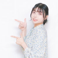 両手で指を差して笑顔で指示する女性の写真