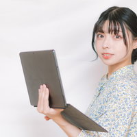 タブレット片手に振り返るエンジニア風女子の写真