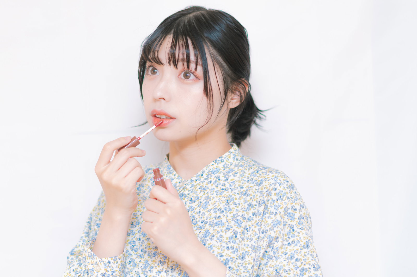 ティントリップを口唇の中央に塗る女性［モデル：高尾実生］