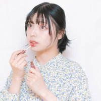 ティントリップを口唇の中央に塗る女性のメイクの写真