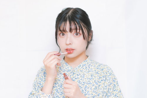 ティントリップを唇に塗る女性のメイク