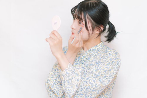 鏡を見ながら眉ブラシで目元を整える化粧テクニック