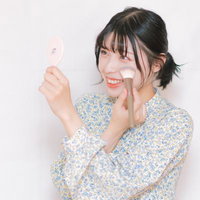チークブラシで化粧する女性の写真