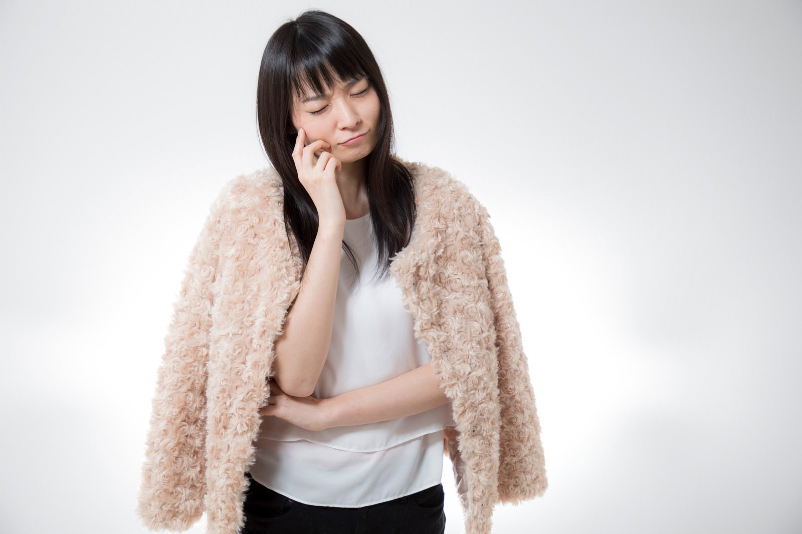 考え込むファーコートの女性［モデル：たけべともこ］