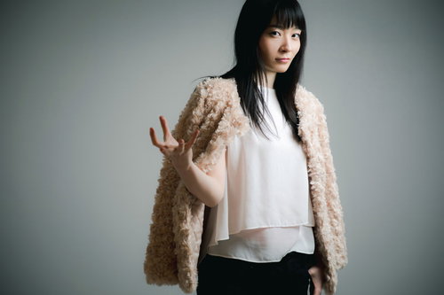 手の平に力を溜めているキメ顔の黒髪女性のポーズ