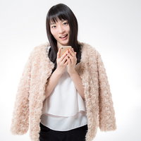 スマホを両手で抱えて微笑む黒髪ボブの女性の写真