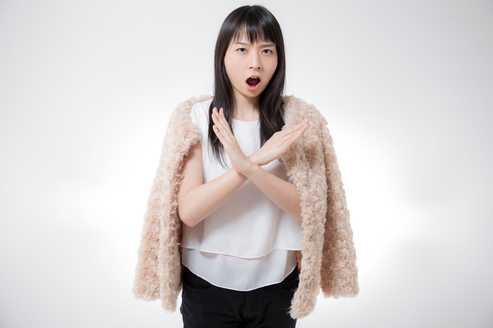 両手でバツ印を作りながら絶対ダメと断りを入れる女性［モデル：たけべともこ］