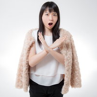 ベージュのカーディガンで絶対ダメと断りを入れる女性の写真