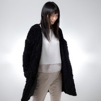 ほくそ笑みながらこちらを見つめる長髪の女性の写真