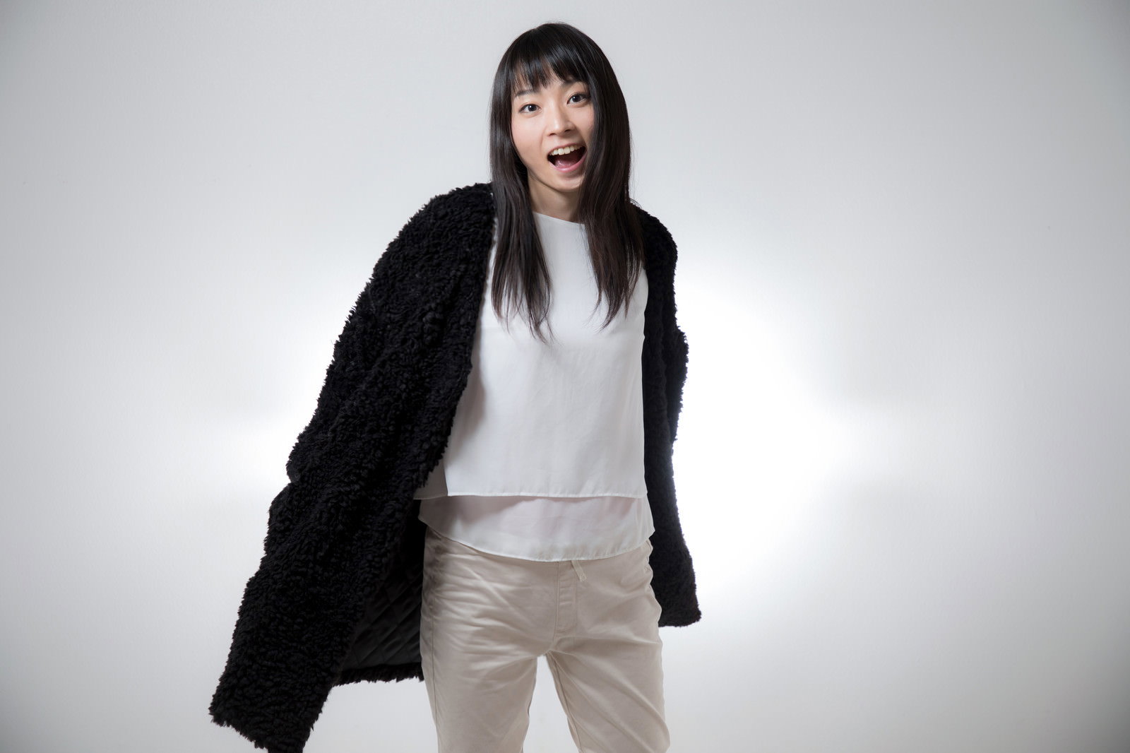口を大きく開けて驚いたような表情で振り返る黒髪ロングヘアの女性［モデル：たけべともこ］