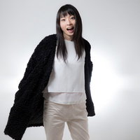 口を大きく開けて振り返る笑顔の女性のポートレートの写真