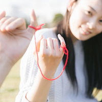 彼と赤い糸で結ばれてます、二人の小指に結んだ絆の象徴の写真