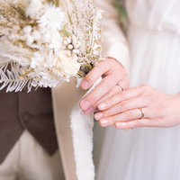 ドライフラワーのブーケを持つ花嫁の2人の結婚指輪の写真