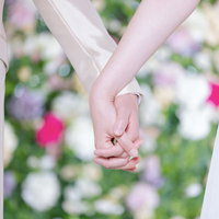 結婚指輪が輝く新郎新婦の手を握り合う瞬間の写真