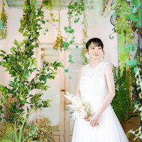 ウェディングドレス姿の彼女と観葉植物に囲まれた室内の写真