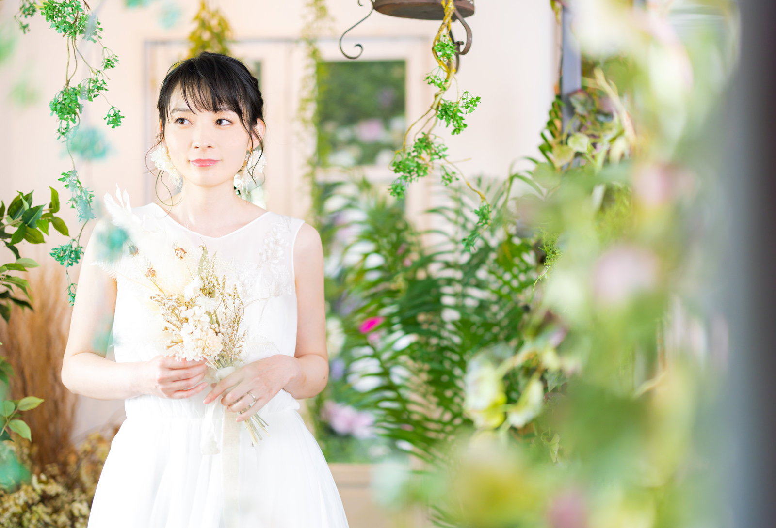 白いウェディングドレスを着てブーケを持つ新婦の女性［モデル：たけべともこ］