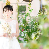 ウェディングドレス姿で歩く白いブーケを持つ新婦の写真