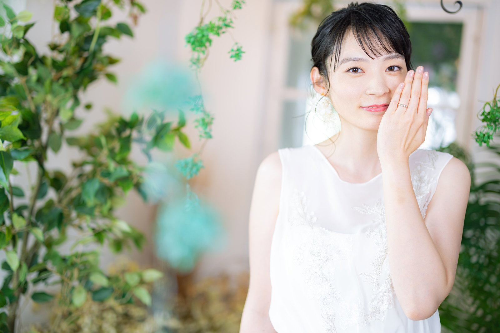 白いウェディングドレスを着た女性が結婚指輪を見せている様子［モデル：たけべともこ］
