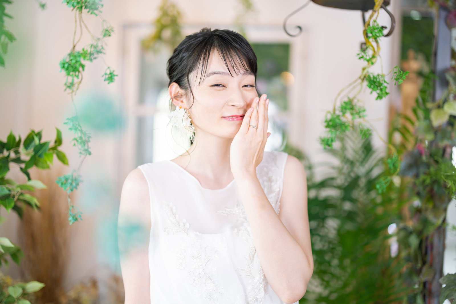 白いウェディングドレスを着た花嫁が結婚指輪を見せる様子［モデル：たけべともこ］