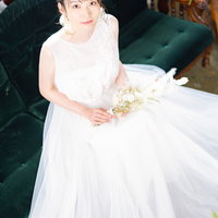 純白のウェディングドレスを着た新婦がブーケを持つの写真