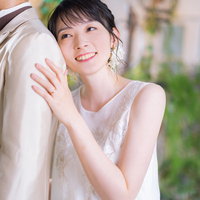 新郎の背中に寄り掛かる幸せそうな表情の新婦の写真