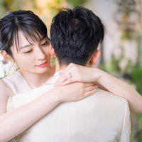 白いウェディングドレスの女性が彼を後ろから抱きしめるの写真