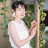結婚指輪をチラリ見せる花嫁の笑顔と室内ウェディングの写真