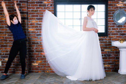 ウェディングフォトに映り込む撮影アシスタントと花嫁